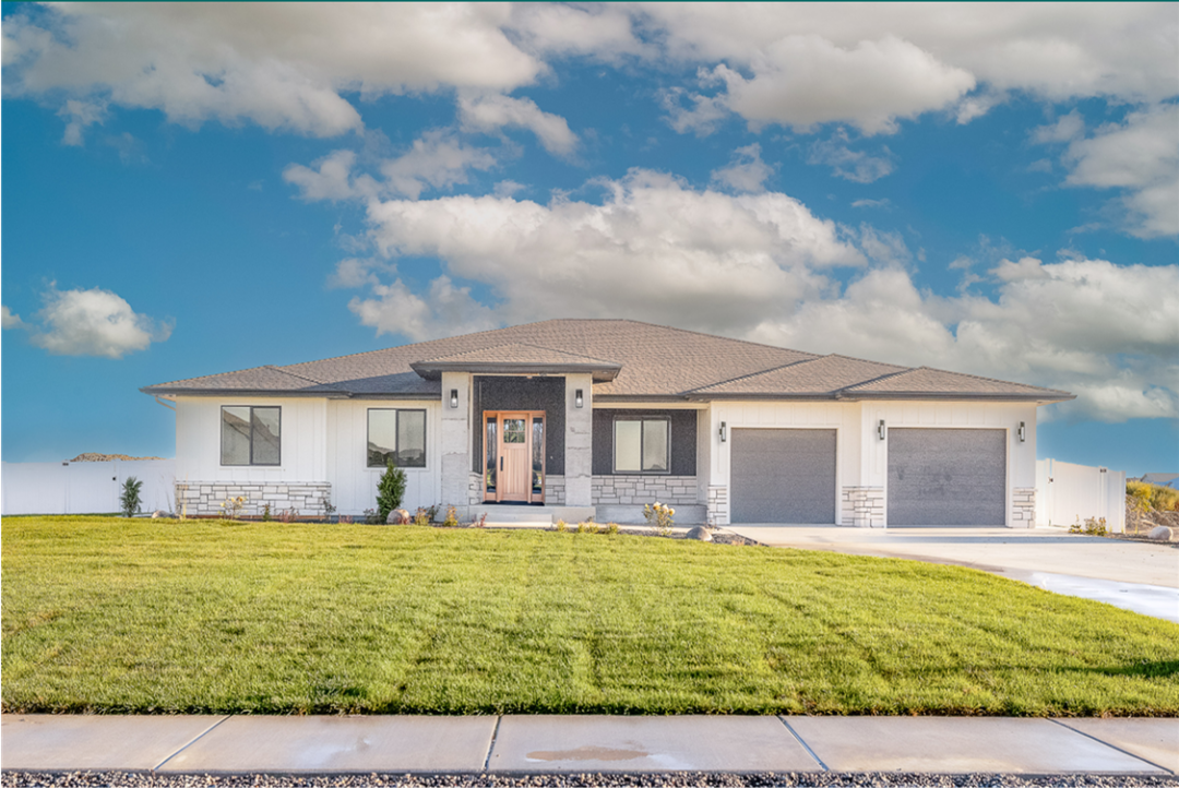 A modern single-family home with a spacious lawn and a two-car garage.