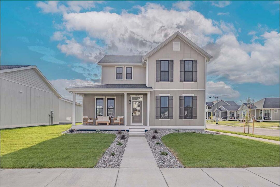 Modern two-story home with a welcoming front porch, surrounded by a well-maintained lawn and neighbo.